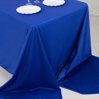 Blue tablecloth draped elegantly on a table with white plates on top.