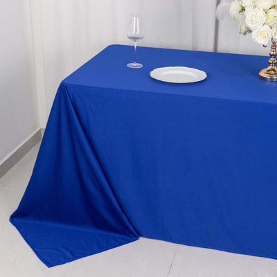 Blue tablecloth draped over a table with a glass and plate on top.
