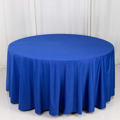 Round blue tablecloth on a circular table against a plain backdrop.