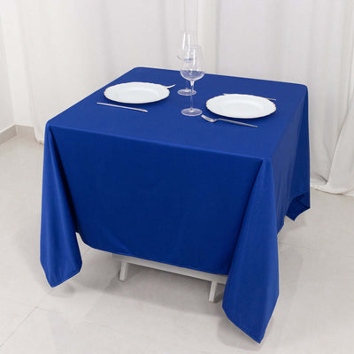 Blue tablecloth draped over a table set for dining with plates and glassware.