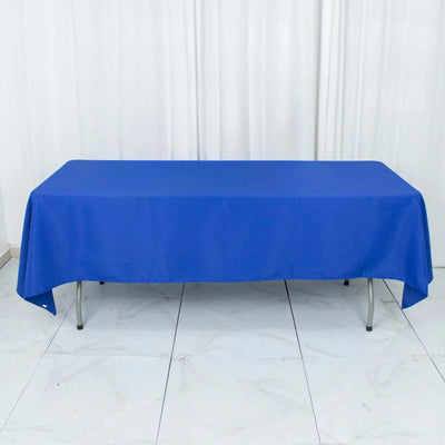 Blue tablecloth draped over a table on a plain backdrop.