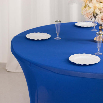 Blue table cover with white plates and elegant decor.