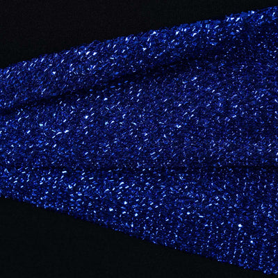 Close-up of shimmering blue glitter fabric on a black background.