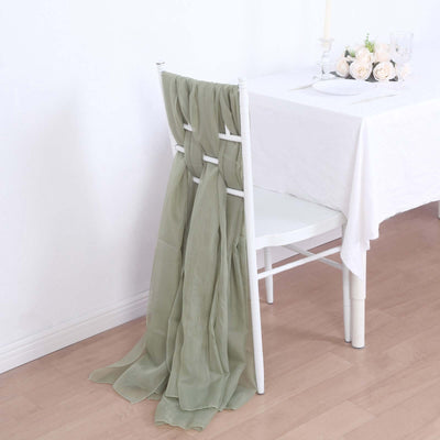 Olive green chiffon drape on a white chair at a dining table