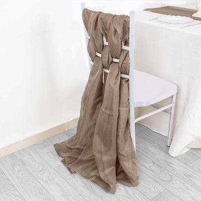 Brown sheer fabric draped over a chair in a stylish setting.