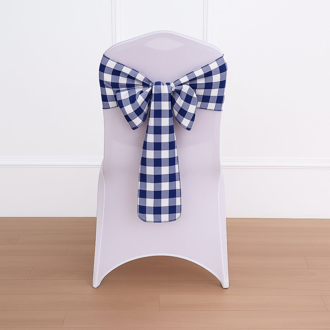 Chair with a blue and white checkered bow on a plain backdrop