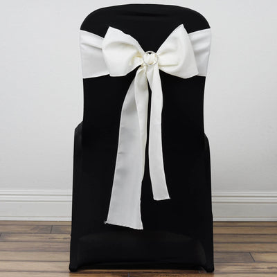 Black chair cover with white satin bow and decorative ring.
