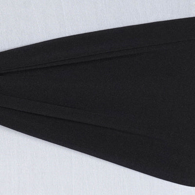 Black fabric drape on a light backdrop showcasing texture and flow.