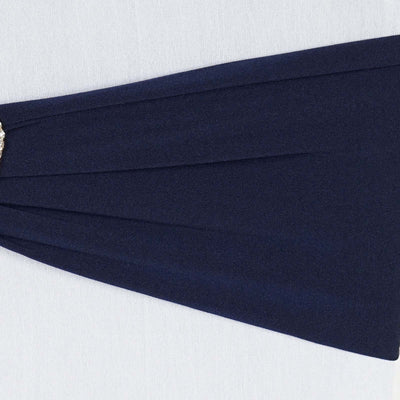 Navy blue pleated fabric with a decorative brooch detail