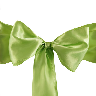 Green satin ribbon bow on a plain backdrop