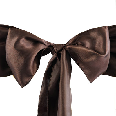 Brown satin bow with long tails on a plain background