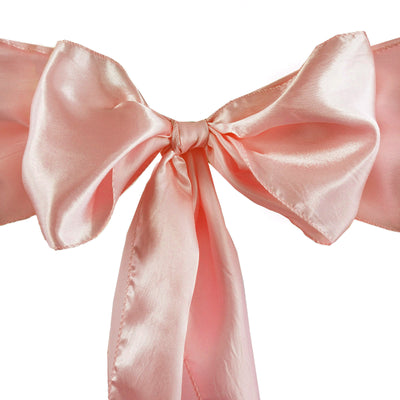 Pink satin ribbon bow on a plain background.