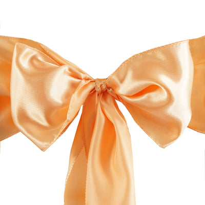 Peach satin ribbon bow with long tails on a white background
