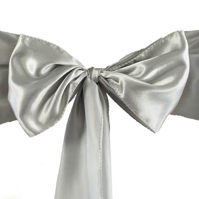 Silver satin bow with long tails on a plain white background.