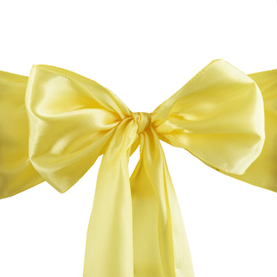 Yellow satin ribbon bow on a white background.