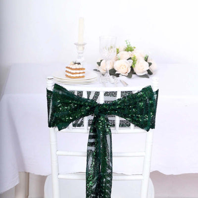 Green sequin chair sash tied on a white chair at a festive table setting.