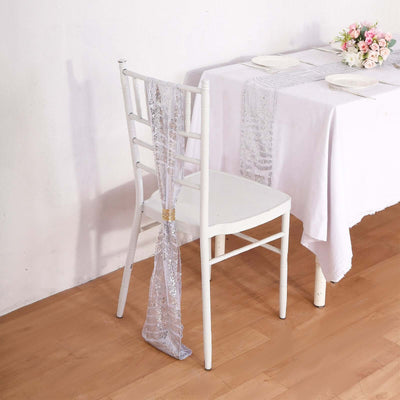 Elegant silver chair sash draped on a white chair at a dining table.