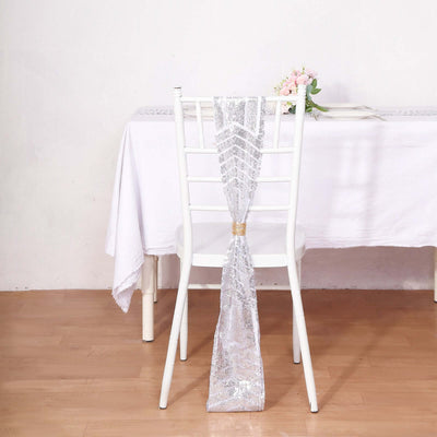 Elegant silver chair sash draped on a white chair at a dining table.