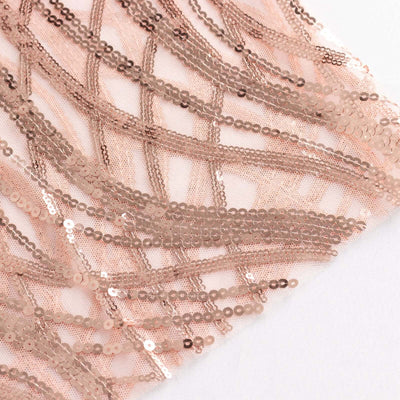 Rose gold sequin fabric with intricate wave patterns.