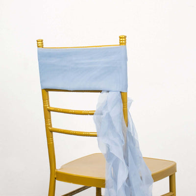 Gold chiavari chair with light blue tulle draped over the back