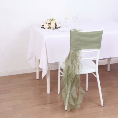 Green chair sash draped elegantly on a white chair at a decorated table.
