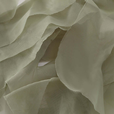 Green sheer fabric draped elegantly, showcasing soft texture and flow.