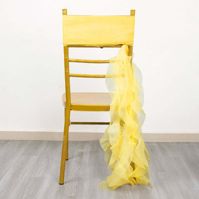 Yellow chair with flowing sheer fabric draped on the back.