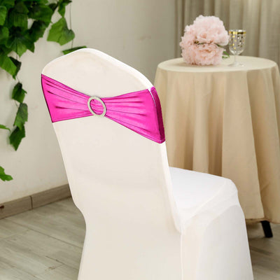 Pink chair sash with rhinestone accent on a white chair in a decorated setting.