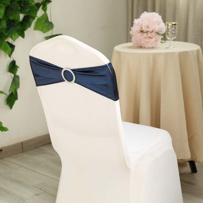 Navy chair sash with rhinestone detail on a white chair in a decorated setting.