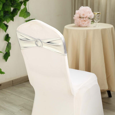 White chair cover with silver sash in elegant setting.
