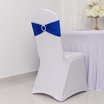 White chair cover with blue sequin bow, styled for events or weddings.