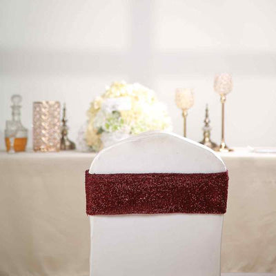 White chair cover with a burgundy sparkly sash, perfect for events and weddings.