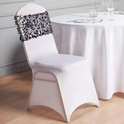 Elegant white chair with decorative sequined backrest against a table setting.