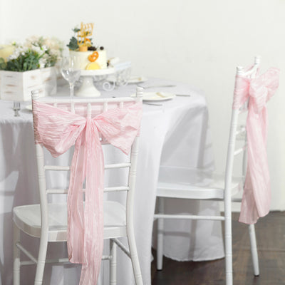 Pink chair sashes tied in bows for elegant event decor.
