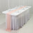 Elegant dining table setup with pink runner and white tableware.