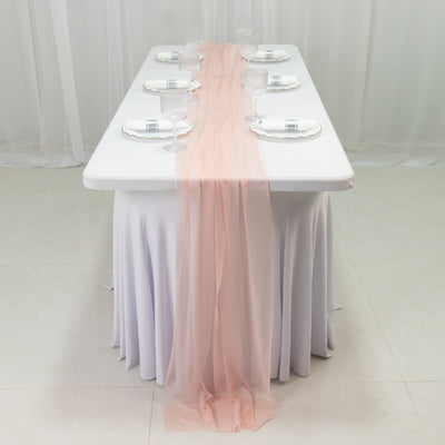 Elegant table setup with pink runner and glassware for events.