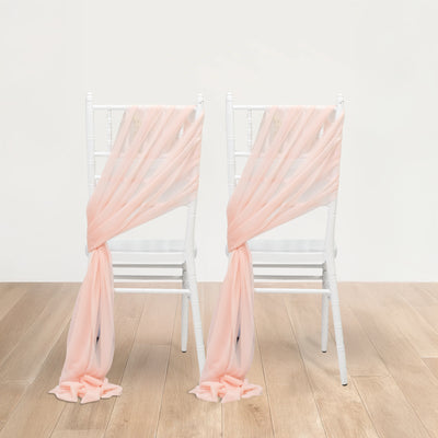 Peach chiffon chair sashes draped over white chiavari chairs