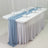 Elegant banquet table set with blue and white tablecloths and glasses.