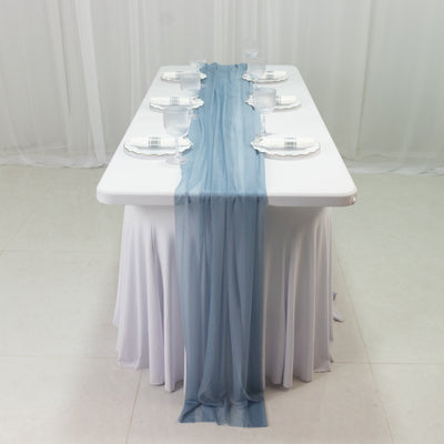 Elegant table setting with blue runner and glassware for special occasions.