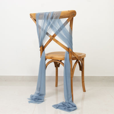Wooden chair with blue draped fabric on a plain background.