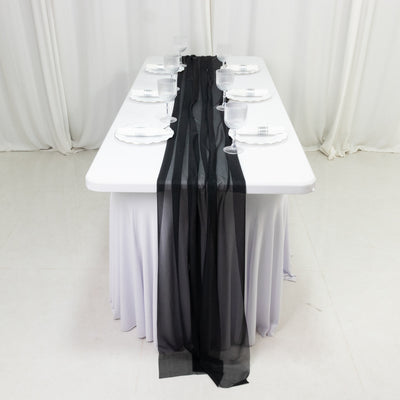 Elegant black and sheer table runner on a white dining table setting.