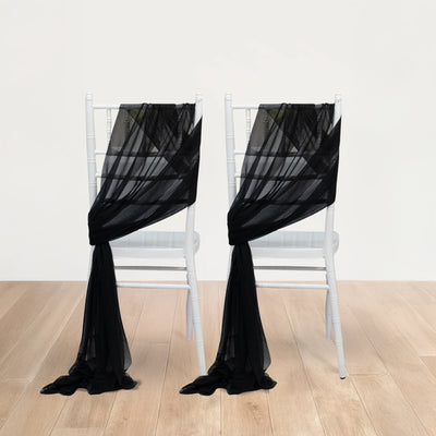 Black sheer chair sashes draped over white chiavari chairs on a plain backdrop.