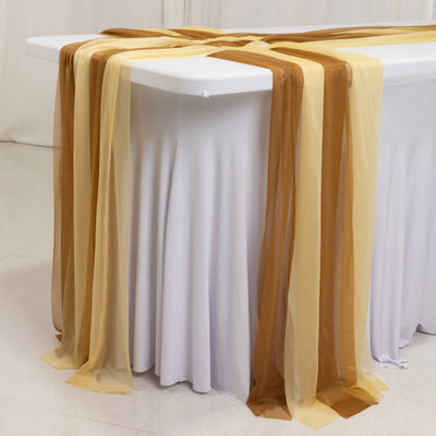 Table draped with sheer gold and brown fabric for elegant decor.