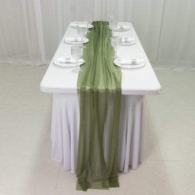 Elegant olive green table runner set on a white table for dining setup.