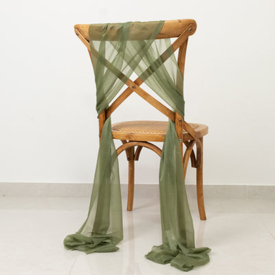 Olive green sheer fabric draped on a wooden chair