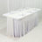 White tablecloth draped on a table set for dining with glasses and napkins.