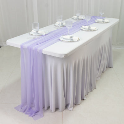 Elegant table setup with lavender draping and glassware for events.