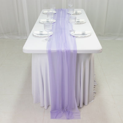 Elegant table setting with lavender table runner and glassware.