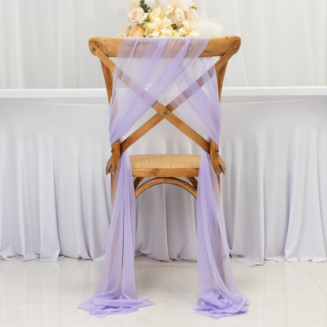 Purple chiffon chair sash draped elegantly on a wooden chair.