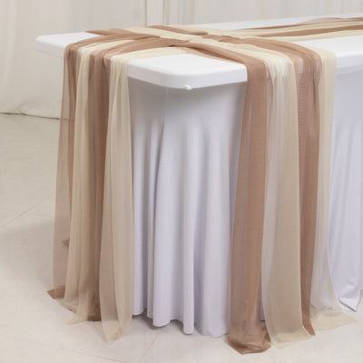 Elegant sheer table runners in beige and brown draped over a white table.